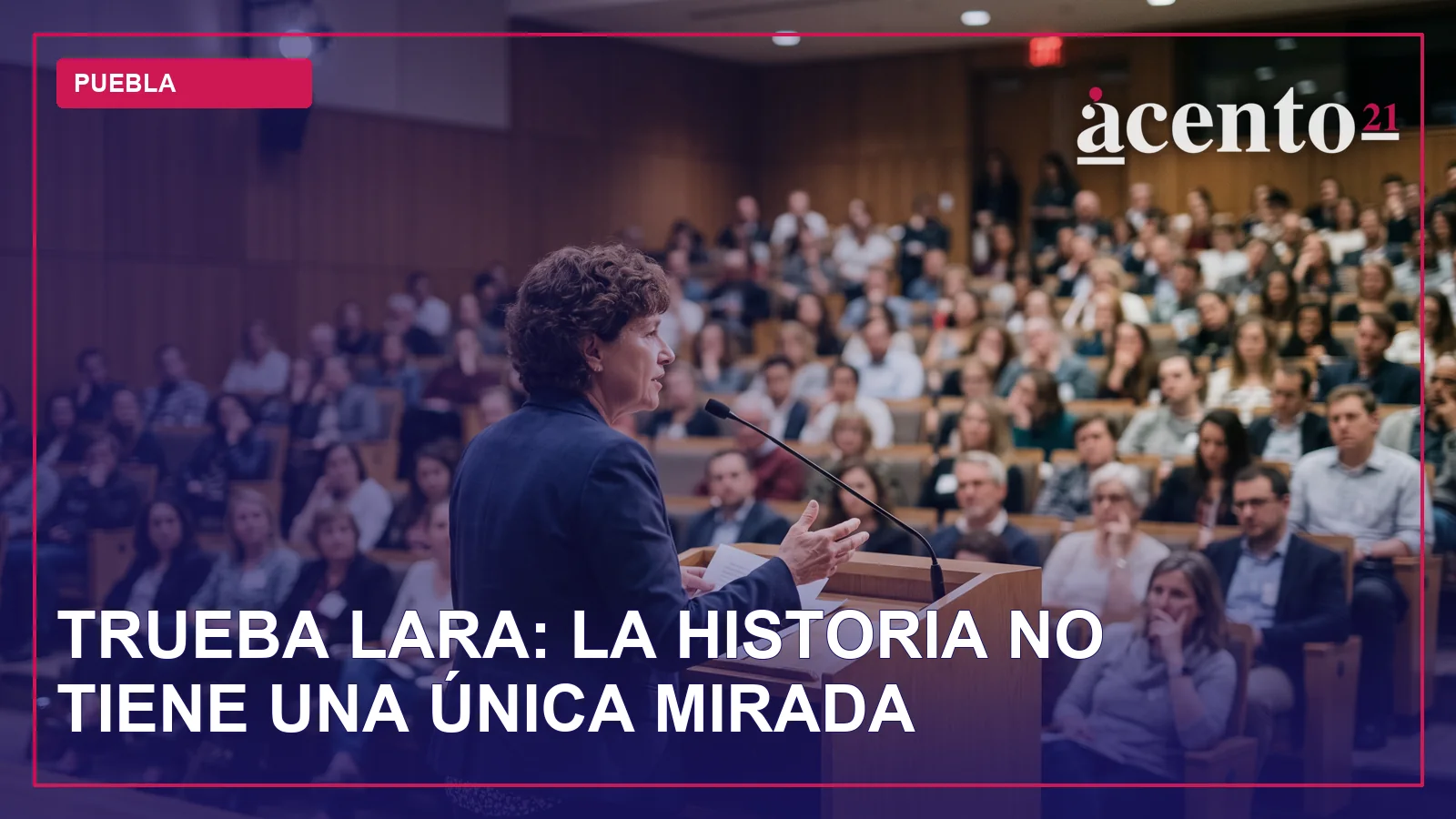 Una persona sentada en un atril, hablando frente a un público en un auditorio.