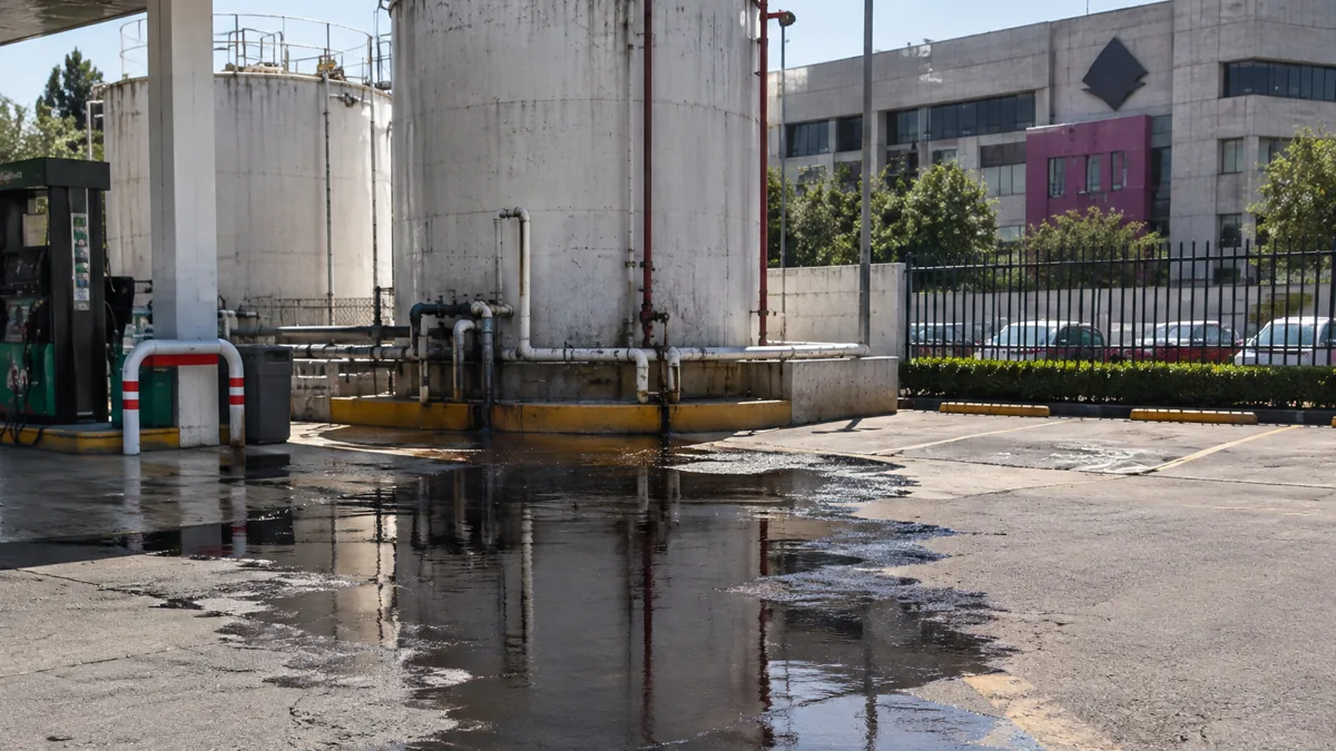 INE evacúa sede central por fuga de combustible en gasolinera cercana Vista aérea de un complejo de edificios con vehículos de emergencia y personal de seguridad en el exterior, indicando una situación de evacuación.